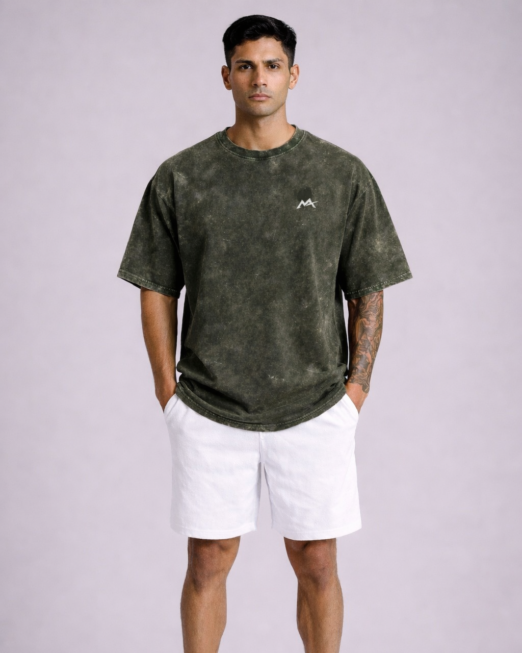 Man wearing a green t-shirt and white shorts on a light gray background