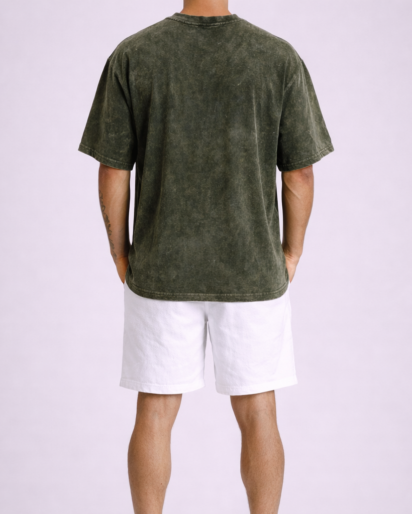 Person wearing a green t-shirt and white shorts on a light purple background